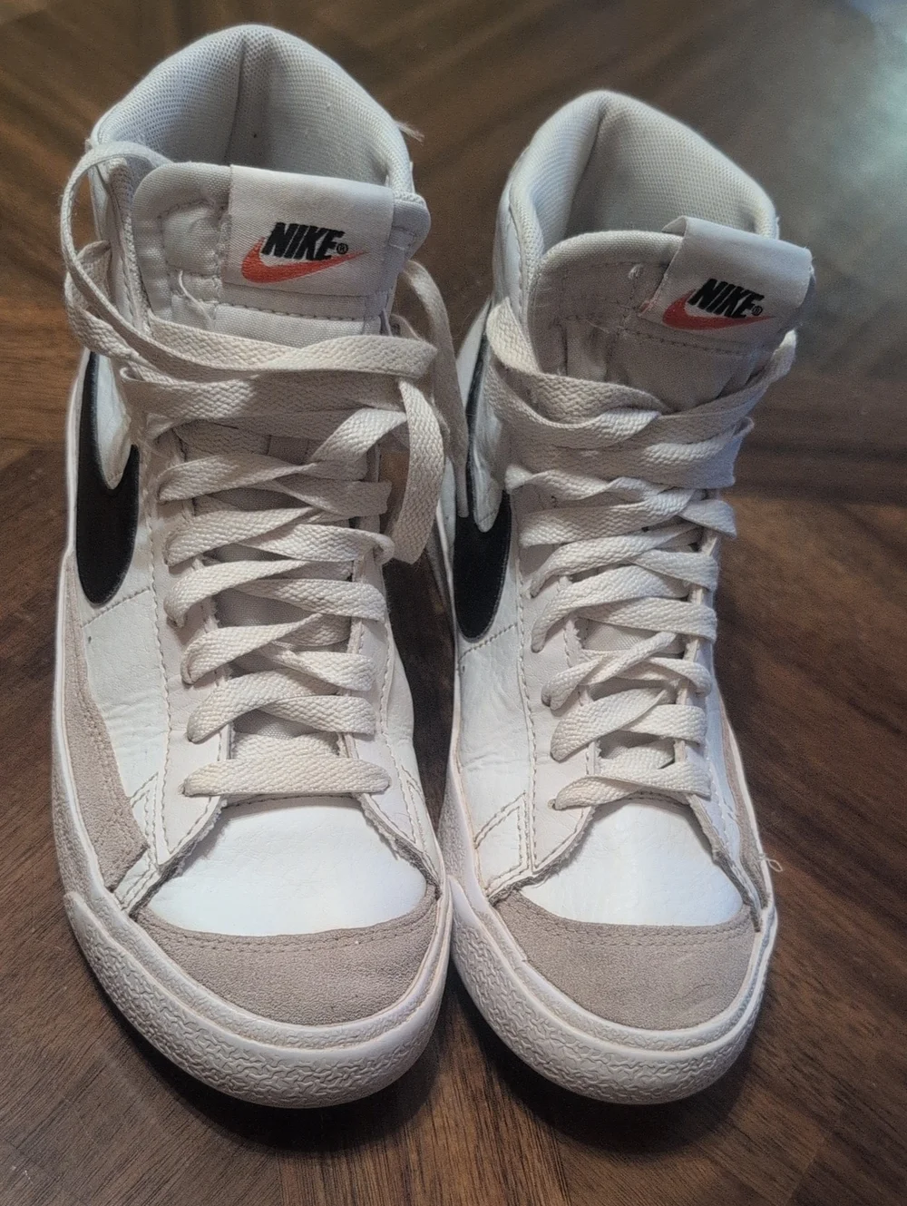 Nike White High-Top Sneakers with Black Swoosh and Orange Logo Accent